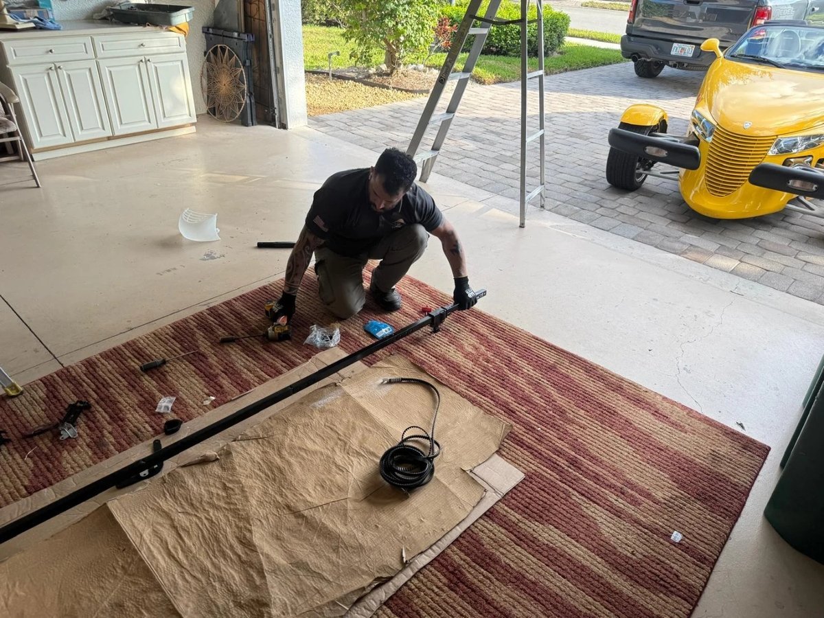 Technician kneeling on a moving blanket to prepare a door section